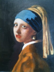 Upper torso and head of a girl in blue and yellow head-dress, looking towards viewer