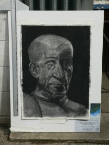 Picture of charcoal head, attached to canvas and with measuring stick.
