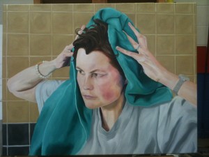 Picture of artist in T-shirt, rubbing hair with green towel