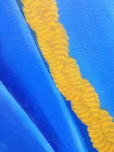 Golden, plaited cord on blue cloth background